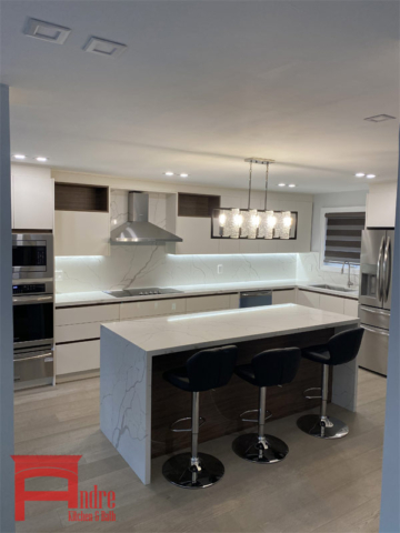 Modern Kitchen With Austrian Laminate, Handle Less Doors, Quartz Countertop And Backsplash, And Waterfall Island