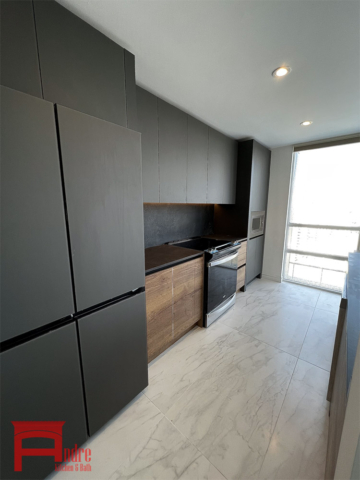 Modern Kitchen With Back Painted Glass Exterior, Handle Less Mechanism, Panel Ready Fridge, And Porcelain Countertop 3